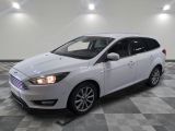 the white ford focus is parked in a large room