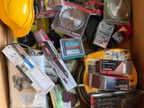 a cardboard box filled with assorted items and a hard hat