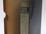 an old book in a cardboard box next to a cardboard box with a green ribbon