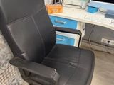 a black office chair sitting in front of a computer desk