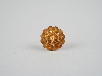 gros plan d'une bague en or sur une surface blanche