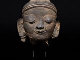 un gros plan du visage d'une femme sculpté sur une statue, sur fond noir