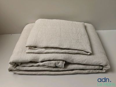 trois draps en lin pliés, empilés les uns sur les autres sur une table