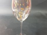 a wine glass that has a gold design on it