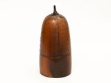 a brown vase with a black top on a white surface