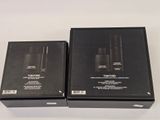 two black boxes with black lids on a white surface with a white background
