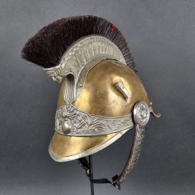 un vieux casque orné d'une plume, posé sur un socle