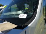 une camionnette blanche garée sur un parking, avec une étiquette indiquant le prix sur le pare-brise