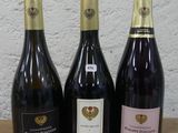 trois bouteilles de vin posées sur une table, l'une à côté de l'autre