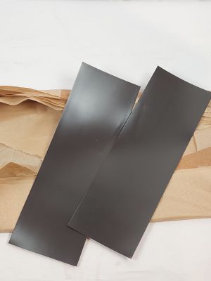 deux morceaux de papier noir posés sur un morceau de papier brun