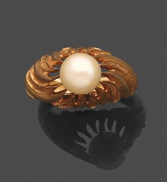 une bague en or sertie d'une perle de culture