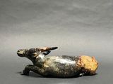 a figurine of a cow with a bird on it ' s back