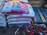 une pile de sacs de croquettes pour chiens posée sur une palette