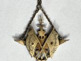 a gold necklace with a cross and a compass on it