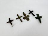 three crosses are shown on a white surface with a white background