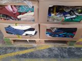 two boxes with clothes in them sitting on a pallet
