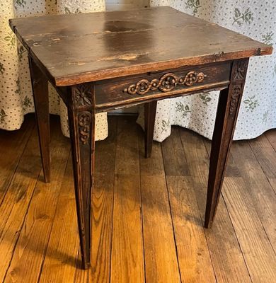 a small table with a wooden top on a wooden floor