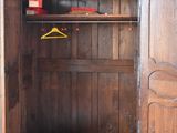 a wooden armoire with a coat rack and a coat hanger
