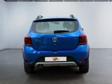 the rear end of a blue car in a white room