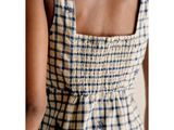 the back of a woman wearing a blue and white checkered dress