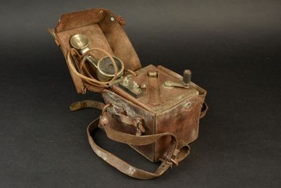 une vieille valise contenant un appareil photo, sur fond noir