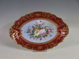 une assiette rouge et dorée ornée de fleurs