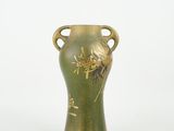 a green vase with a gold decoration on it