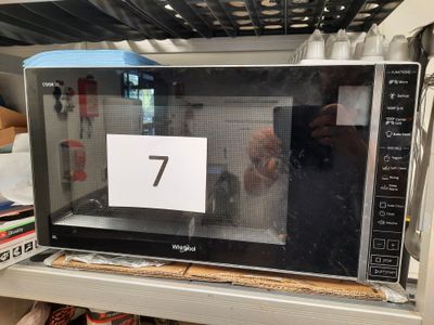 quelqu'un en train de prendre une photo d'un micro-ondes posé sur une étagère dans un magasin