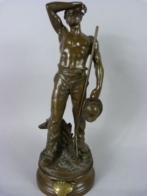 statue en bronze représentant un homme tenant un chien et un chapeau