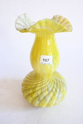 un vase jaune sur lequel est collée une étiquette blanche