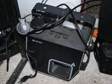 a small black machine sitting on the floor next to other appliances