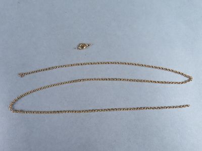 a close up of a gold chain on a white surface
