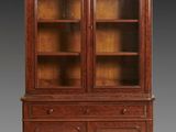 an antique mahogany bookcase with glass doors