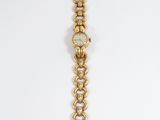 a close up of a wrist watch with a chain around it