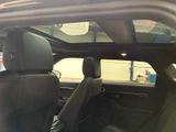 the interior of a car with the sunroof down and the door open