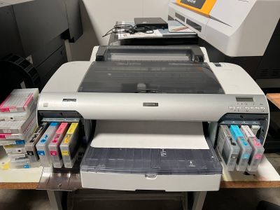 une imprimante posée sur un bureau, avec une autre imprimante à côté