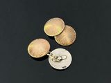 a close up of three gold earrings on top of a coin