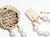 an image of a pearl necklace with a gold clasp and a pair of earrings