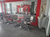 une photo d'un salon avec des chaises et des tables