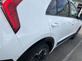 the rear end of a white car parked in a parking lot