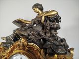 a statue of a woman reading a book on top of a clock
