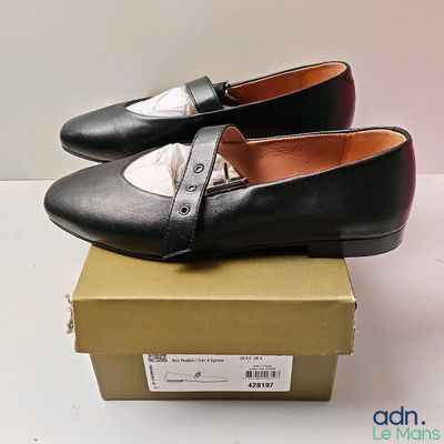 une paire de chaussures noires et blanches posée sur une boîte