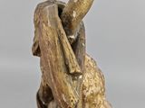 bronze statue of a woman holding a baseball bat on a table