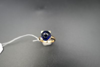 une bague sertie d'une pierre bleue, posée sur une table