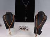 three necklaces and a necklace with a cross on a stand