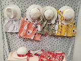 many hats on a table with a cloth on top of it