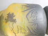 un vase orné d'un arbre, posé sur une table