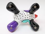 a ceramic figurine of a turtle made of black, white, purple, and red