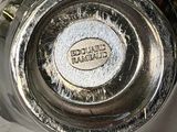 a close up of a silver vase with a label on it