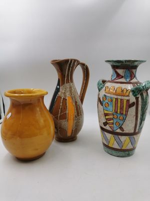 trois vases posés l'un à côté de l'autre sur une table